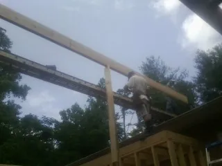 Carpenter setting a ridge beam over a new addition frame — Ice Dam Removal by Roofing Brothers in Quaker Hill