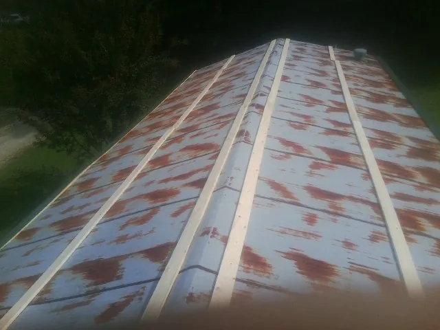 Rusted metal roof panels with new wood purlins before replacement — Storm Damage Roof Repair in Quaker Hill by Roofing Brothers