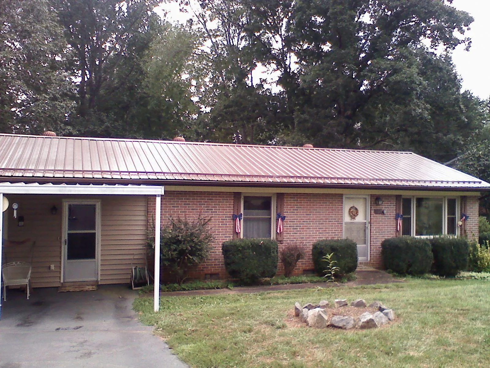 Bronze metal roof and carport on a brick ranch home — Roof Repair work by our crew in Quaker Hill